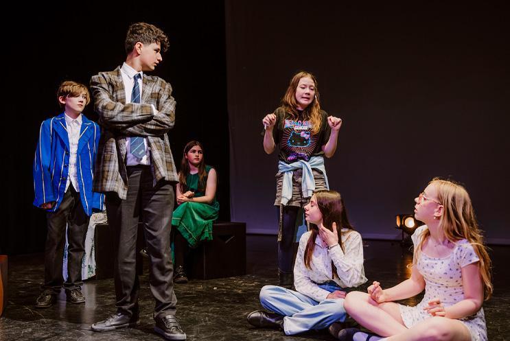 Young performers dressed formally both sitting and standing