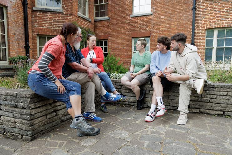 Judges sat giving feedback to winners on stone wall.