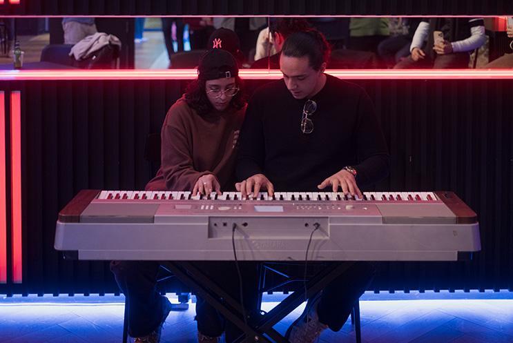 Two musicians playing a keyboard together