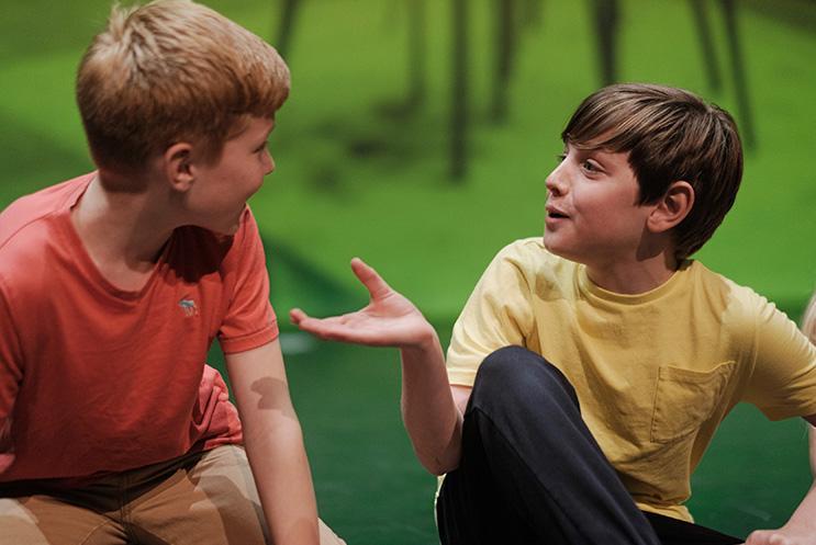 Two children on stage talking to each other