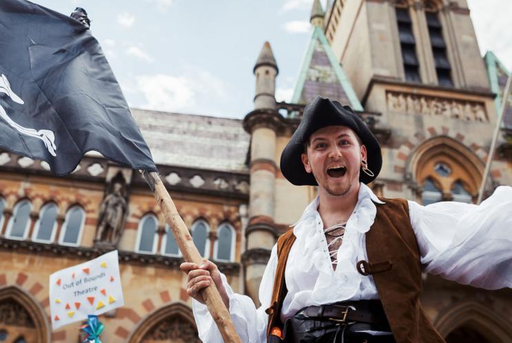 A pirate waving a flag in front of Winchester Guildhall