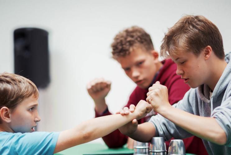 Young magicians doing  performing a trick with a young audience member