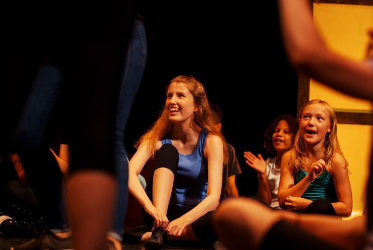 A young girl watching dancers perform around her