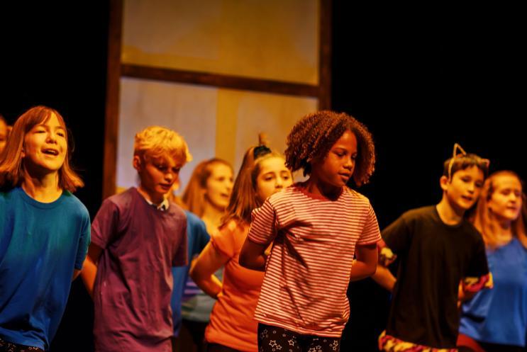 Young people dancing on stage and smiling.