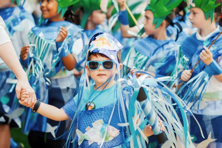 School boy dressed in carnival costume and wearing sunglasses.