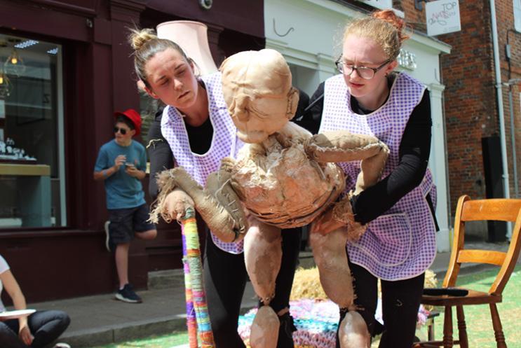 Two female performers with puppet