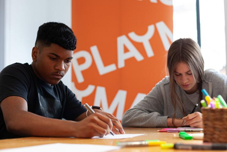 Young people writing with pen and paper